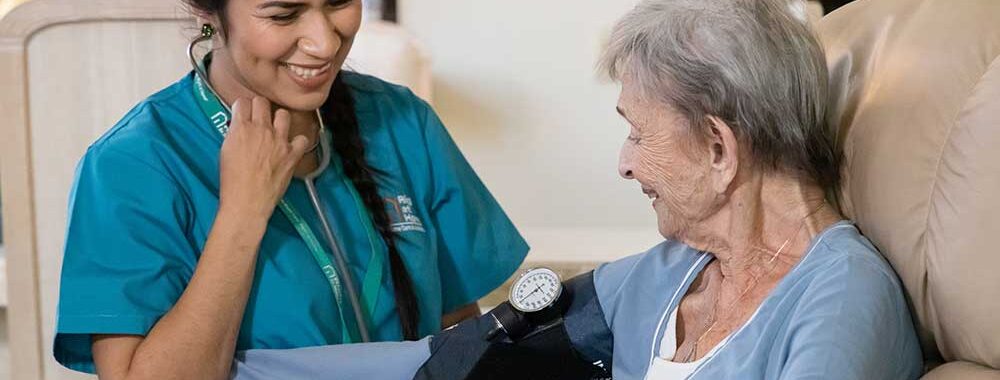 caregiver taking seniors blood pressure