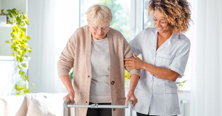 nurse helping older woman with walker